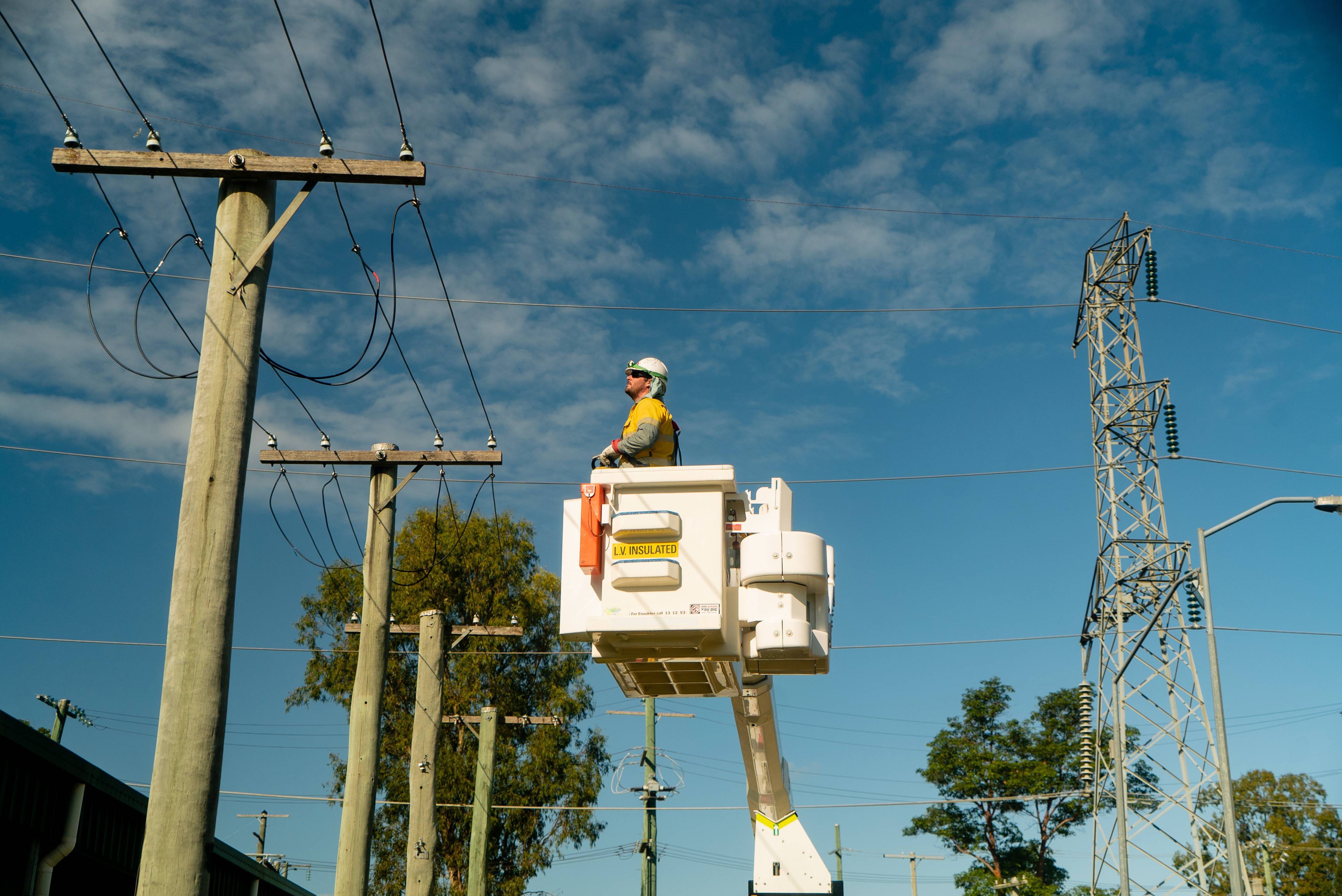 Field crew in cherry picker near powerlines