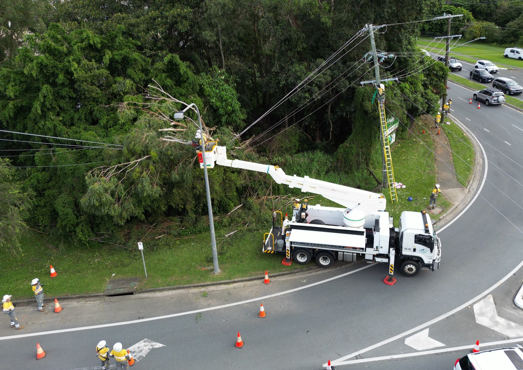 Aerial view of crews working on powerlines amongst rainforest at Currumbin