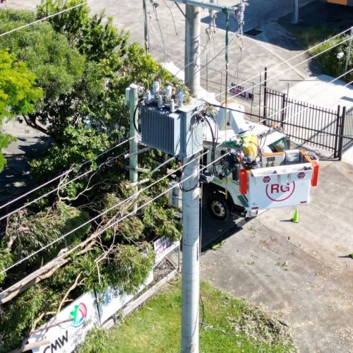 Field crew member in cherry picker working on powerlines