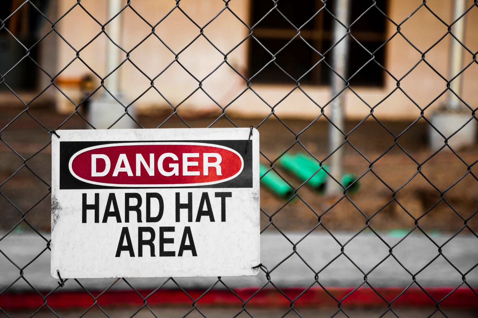 Danger hard hat area sign on a fence