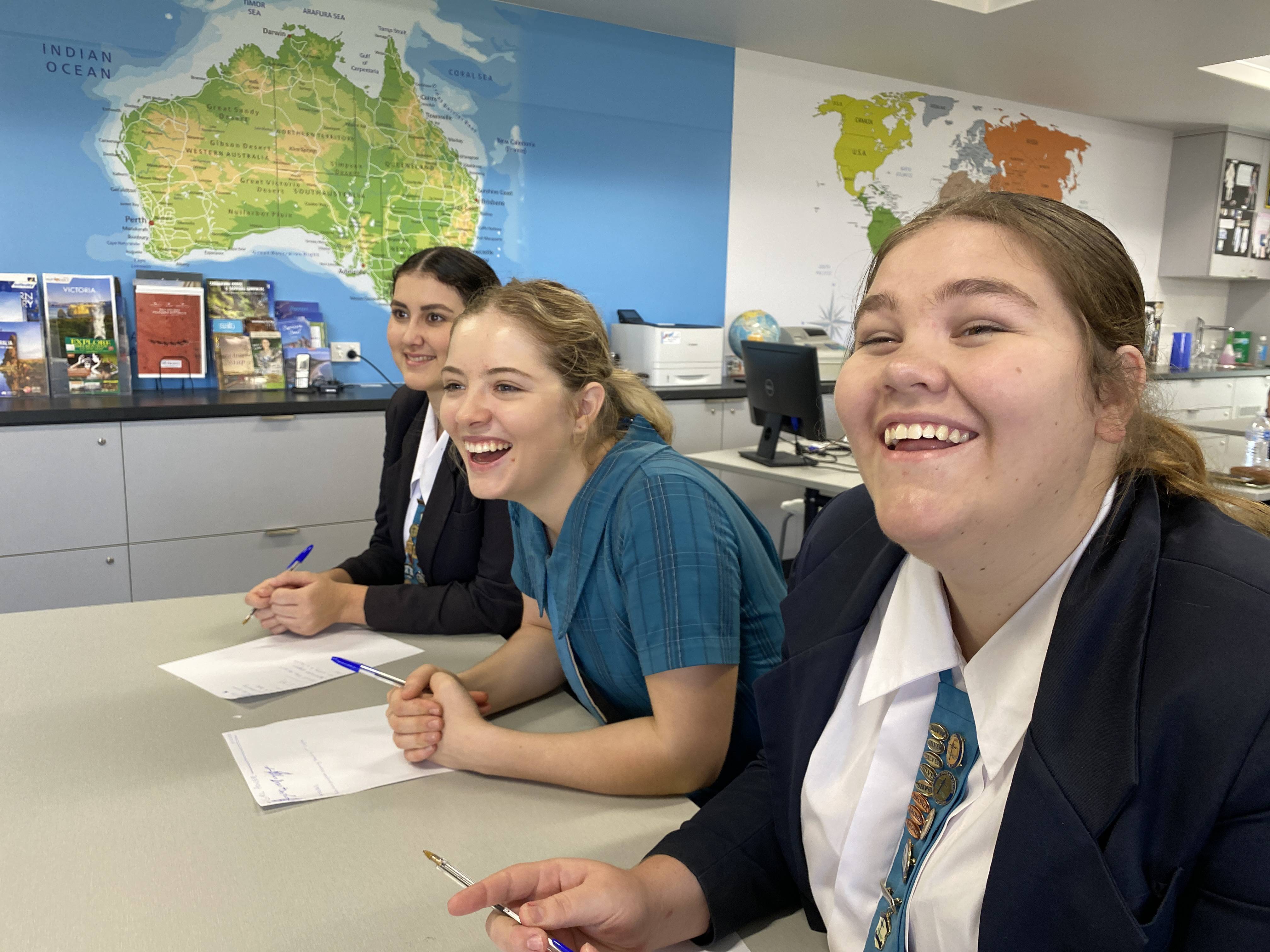 3 high school girls laughing in classroom
