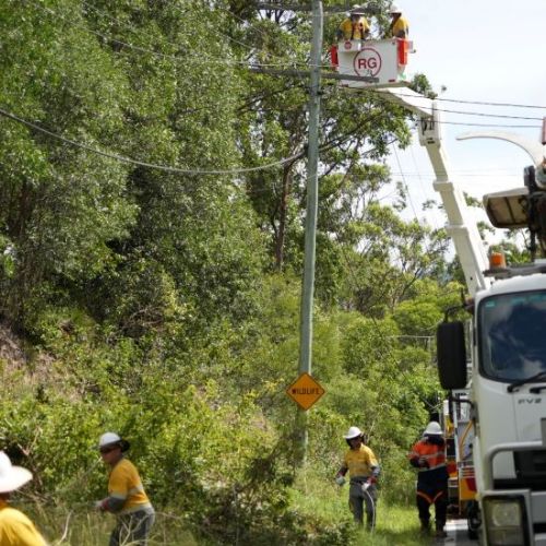 A number of crew on ground and in cherry picker working to restore power