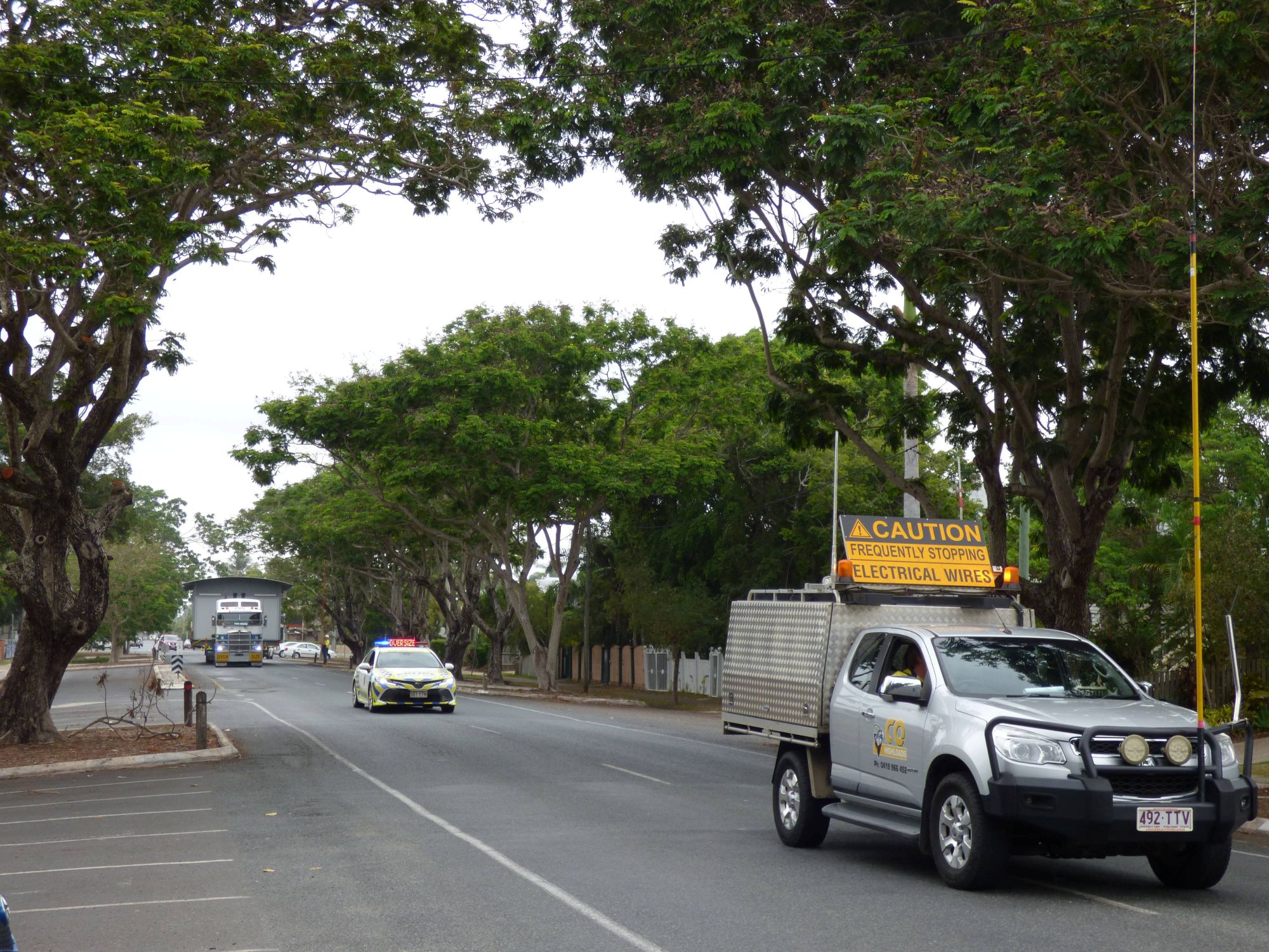 Transporting a house on a truck with police escort in a street