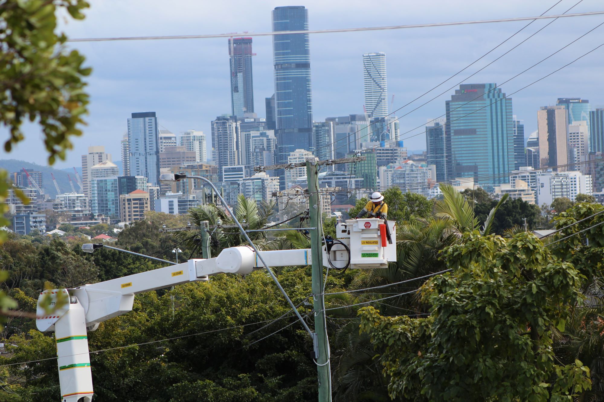 Crew up in a cherry picker with the city in the background