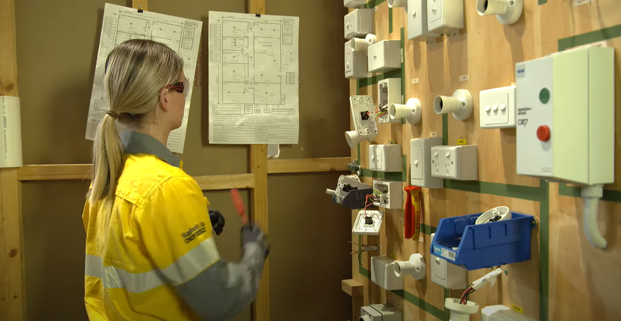 Female crew member in training looking at ligh switches