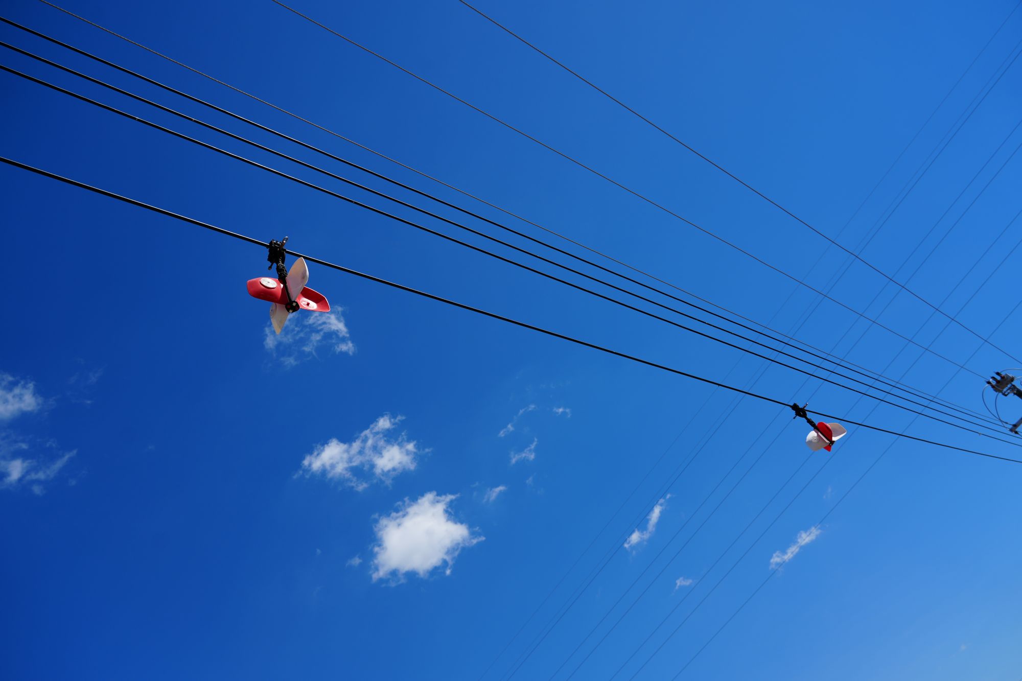 Powerline markers on powerlines with blue sky in background