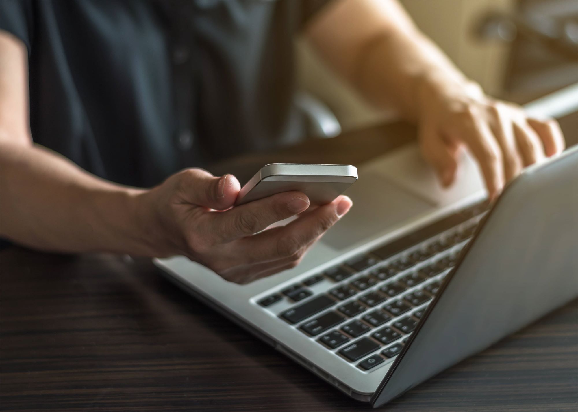 Man using laptop and mobile phone