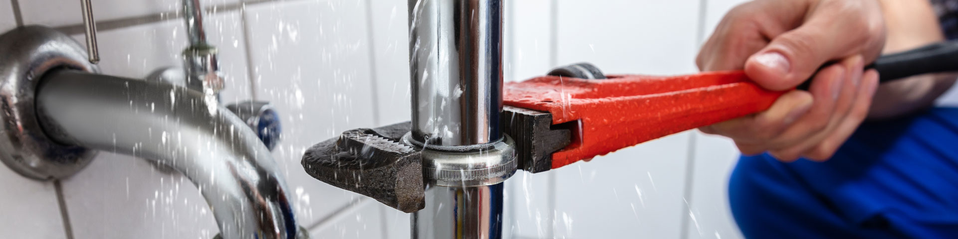 A plumber using a wrench to tighten a tap