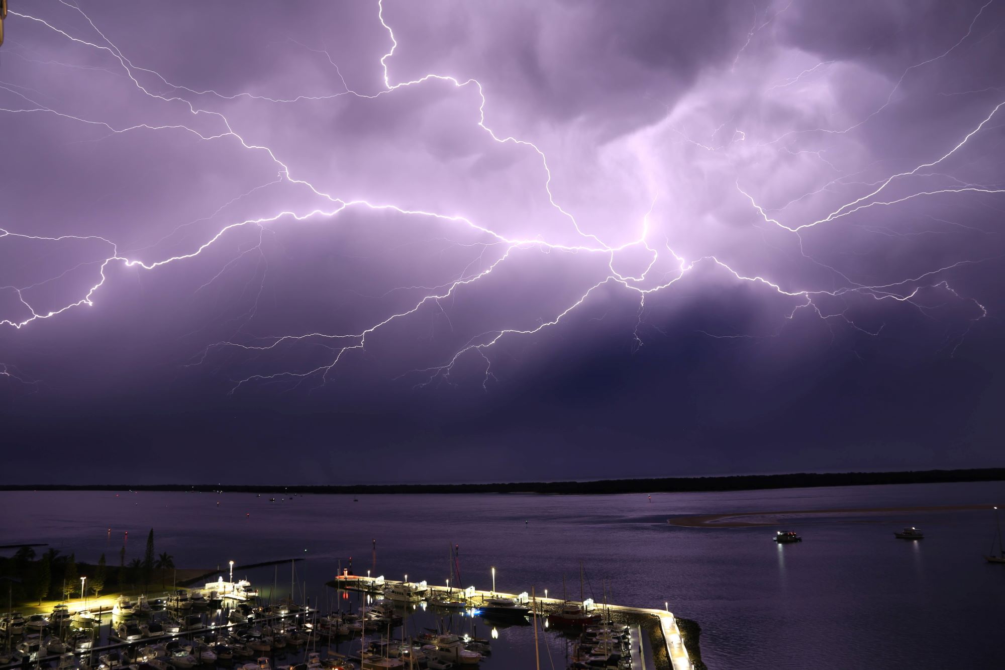 Lightning strike in purple sky over marina