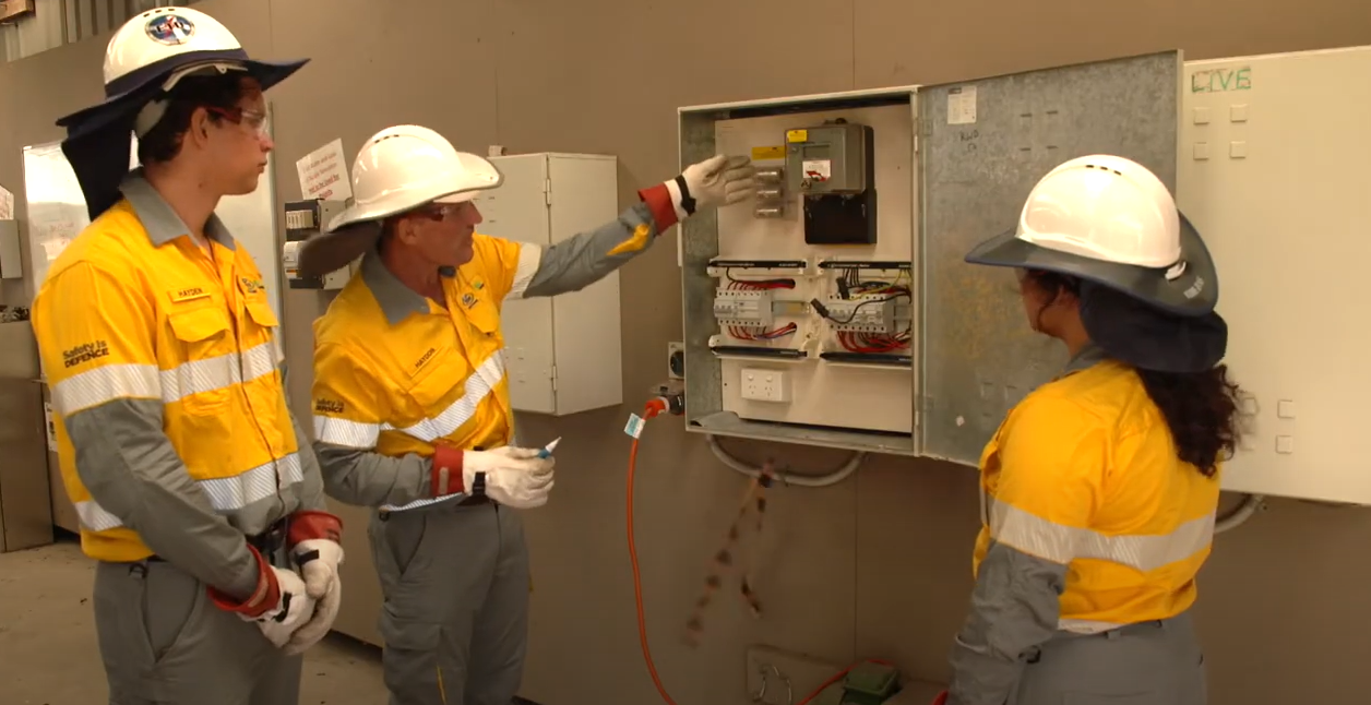 Trainer showing new apprentices how to read a switchboard