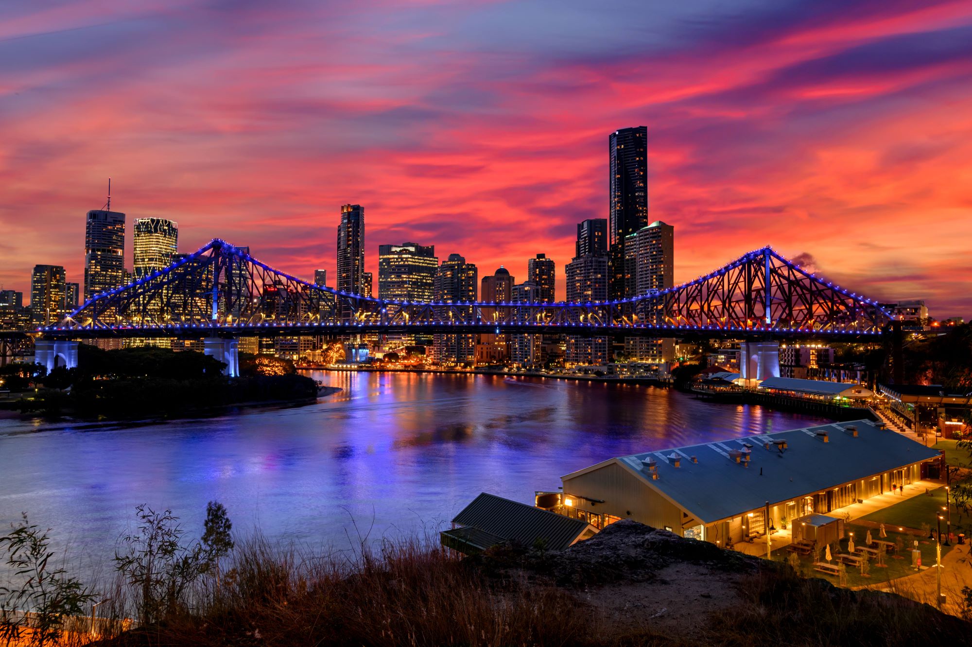 Sunset over Brisbane city with buildings and the Storage Bridge